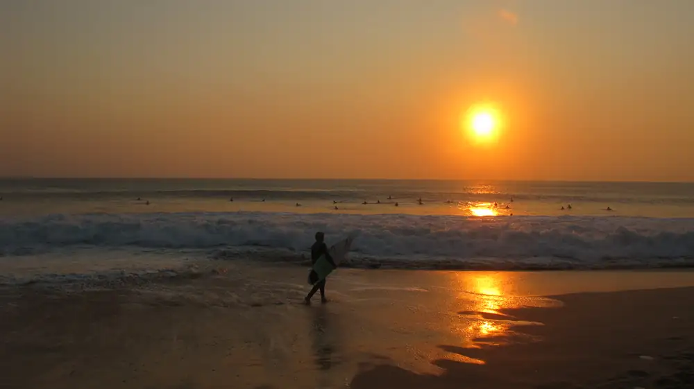 Surfer at sunset at Supertubos, Peniche